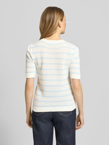 Frauenmodel trägt Strickshirt mit Rundhalsausschnitt Modell 'DALO' von Vila aus Reine Baumwolle im Regular-Fit, Strukturmuster, Rückenlänge 56 cm, Ärmellänge 28 cm, Ganzkörperansicht Rückansicht.