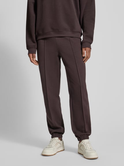 Männermodel trägt Regular Fit Sweatpants aus Baumwoll-Mix von Lacoste, Optik: Unifarben, Logo-Stitching, Piqué-Struktur, Ganzkörperansicht von vorne.