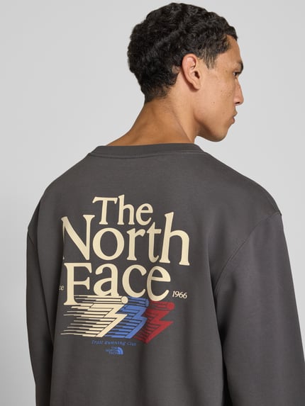 Männermodel trägt Relaxed Fit Sweatshirt aus katoenmix von The North Face met logoprint, heren sweatshirt, ruglengte maat M 68 cm, mouwlengte maat M 68 cm, ronde hals, elastische boordjes, Ganzkörperansicht Rückansicht