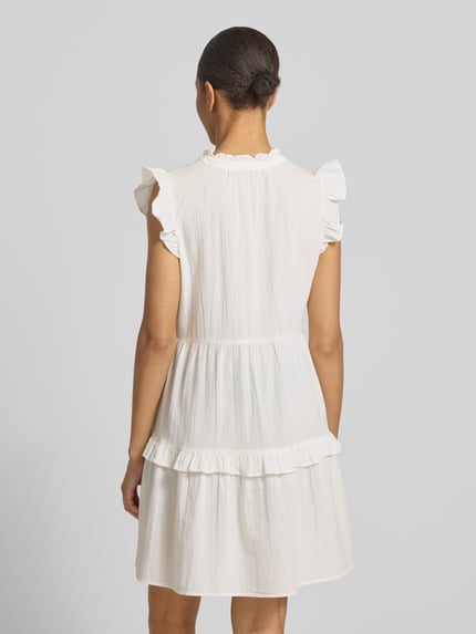 Männermodel trägt unifarbenes, weißes, figurumspielendes Freizeitkleid aus reiner Baumwolle Modell 'Dichte' von Vero Moda, Flammgarnstruktur, Mini-Länge, kurze Ärmel, tiefer V-Ausschnitt, Ganzkörperansicht Rückansicht