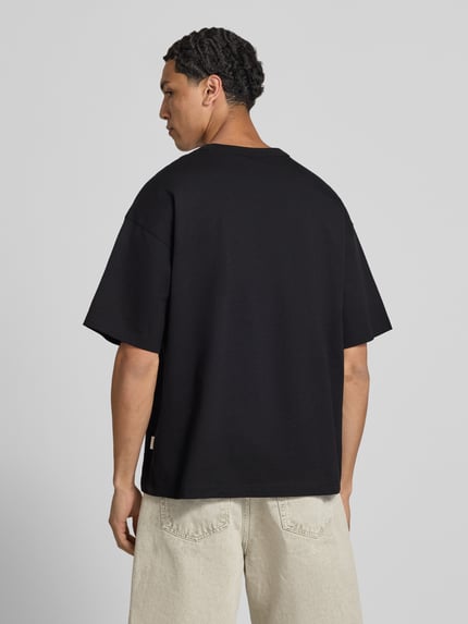 Mannenmodel draagt T-shirt met motiefprint model 'MENTON' van Jack & Jones, puur katoen, relaxed fit, ronde hals, ruglengte maat M 71 cm, geheel van achteren.