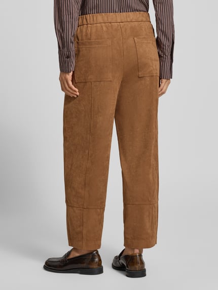 Frauenmodel trägt Regular Fit Lederhose mit großen Taschen von OPUS PANTS, unifarbene Struktur, 7/8-Länge, Ganzkörperansicht Rückansicht.