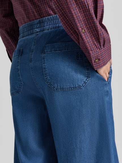Frauenmodel trägt Wide Fit Jeans aus Lyocell-Mix von Smith and Soul in Blau mit elastischem Bund und Gesäßtaschen, Nahaufnahme Rückansicht.
