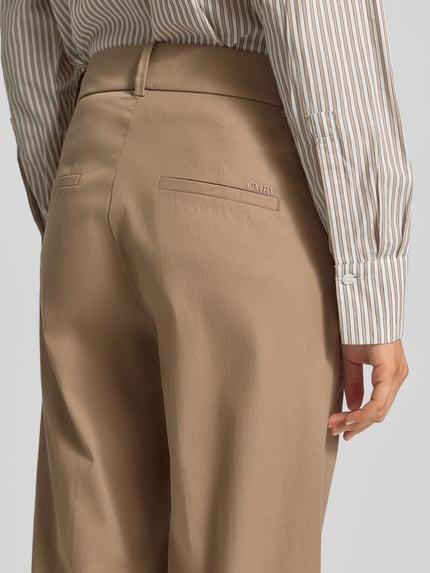 Vrouwenmodel draagt Regular Fit Chino uit katoenmix model 'CALIFORNIA' van Cambio, effen popeline, achterzakken, detailopname rug.