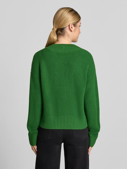 Männermodel trägt Strickpullover aus Schurwolle mit V-Ausschnitt von windsor. w kolorze zielonym, relaxed fit, gruby splot, długość pleców 54 cm, długość rękawa 58 cm, widok całej sylwetki od tyłu