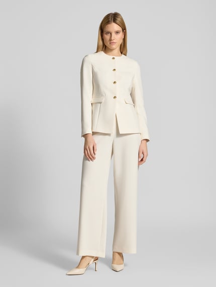 Modelka prezentuje Blazer mit Schmuckknöpfen von Jake*s Collection, mieszanka materiałów z dodatkiem wiskozy, krój regular fit, okrągły dekolt, ozdobne guziki, kieszenie z patką, długość tyłu w rozmiarze 36: 64 cm, szerokość w rozmiarze 36: 44 cm, długość rękawów w rozmiarze 36: 63 cm, jasny kolor, gładka tekstura, pełny widok z przodu.