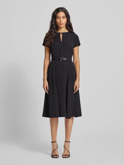 Kobiece modelka nosi Knielanges Kleid mit Taillengürtel od Lauren Ralph Lauren, taliowany krój, długość do kolan, wycięcie w kształcie łezki, pasek w talii, wszyty zamek błyskawiczny, długość tyłu 99 cm, szerokość klatki piersiowej 34 cm, długość rękawa 14 cm, czarna tkanina, gładka struktura, pełny widok z przodu.