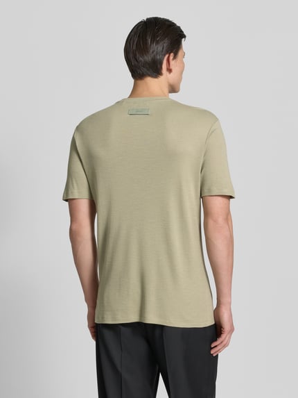 Męski model nosi Regular Fit T-Shirt aus Lyocell-Leinen-Mix Modell 'DULEROSTEE' von HUGO, gładki, jasnobeżowy, krój regular fit, detal z logo, krótkie rękawy, widok całej sylwetki z tyłu.