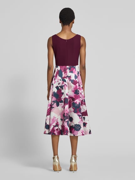 Vrouwenmodel draagt Tailliertes Cocktailkleid mit Allover-Muster van Vera Mont in bordeauxrood en roze met bloem all-over motief, volledige lichaamsweergave achteraan. Context: Dames cocktailjurk van Vera Mont