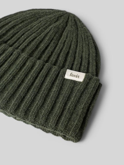 Produktfoto, Beanie aus Woll-Mix von Forét in dunklem Grün, Ripp-Optik, breiter Umschlag, Label-Patch mit Logo-Schriftzug