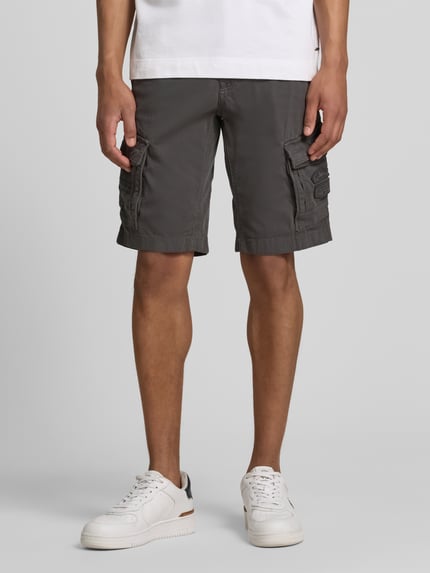 Männermodel trägt Bermudas mit Pattentaschen und Label-Stitchings von PME Legend in Grau mit Eingrifftaschen, Knopf-Reißverschluss, Ganzkörperansicht von vorne.
