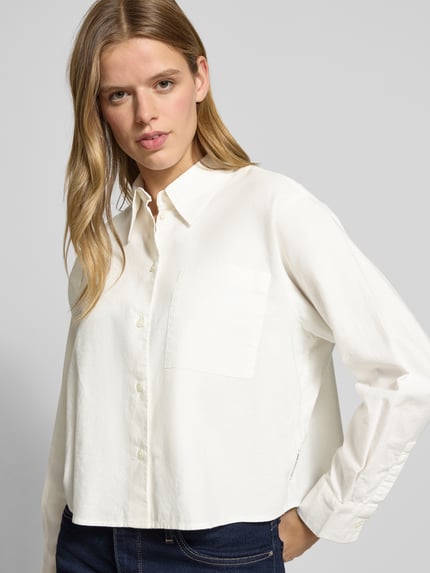 Frauenmodel trägt Boxy Fit Hemdbluse aus reiner Baumwolle von Marc O'Polo, Optik: Unifarben, Hemdblusenkragen, Brusttasche, Langarm mit Manschette, einreihige Knopfleiste, Struktur und Textur sichtbar, Ganzkörperansicht von vorne.