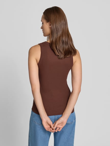 Modelka kobieca ma na sobie brązowy Tanktop in Ripp-Optik Modell 'HONEY' od Topshop, bawełna z domieszką elastanu, krój slim fit, dekolt okrągły, długość pleców w rozmiarze S: 53 cm, widok całej sylwetki z tyłu.