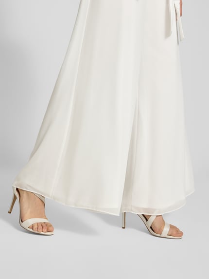 Vrouwenmodel draagt Jumpsuit aus fließendem Stoff mit Bindegürtel van Vera Mont, wit, wijde benen, chiffon, detailopname benen
