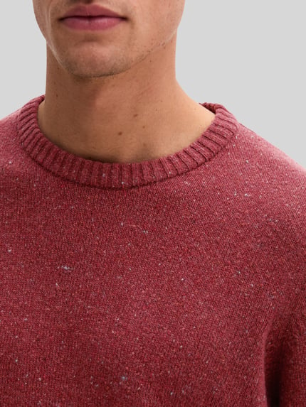 Männermodel trägt Pullover mit Logo-Detail von MARC O'POLO in melierter Strickoptik, Struktur, Rundhals, Nahaufnahme Oberkörper.