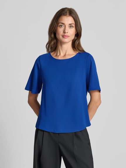 Vrouwenmodel draagt Regular fit blouse met korte mouwen met boothals van s.Oliver BLACK LABEL, effen blauw, gladde stof, busteschot, frontale borsthoogte. Dames Kurzarmbluse von s.Oliver BLACK LABEL.