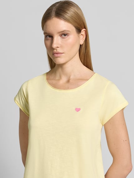Frauenmodel trägt T-Shirt mit Stitching und Rundhalsausschnitt von Christian Berg Woman in Hellgelb, reine Baumwolle, Regular Fit, Nahaufnahme Oberkörper.