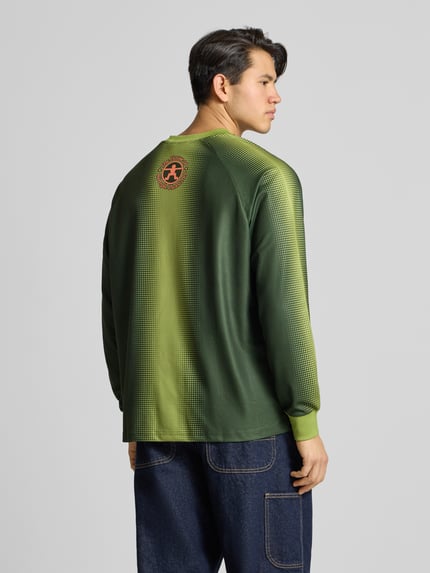 Männermodel trägt Trikot mit Label-Print und Rundhalsausschnitt von DEUS EX MACHINA in Grün, Regular Fit, Longsleeve, Rückenlänge 71 cm, Ärmellänge 65 cm, Ganzkörperansicht Rückansicht.