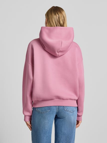 Frauenmodel trägt Relaxed Fit Hoodie aus Baumwoll-Mix mit Label-Detail von REVIEW in Rosa, glatte Textur, lässige Passform, Ganzkörperansicht Rückansicht.