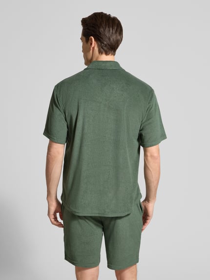 Männermodel trägt slim fit Freizeithemd aus Frottee von MCNEAL in olivgrün, Baumwoll-Mix, korte mouw, reverskraag, rugaanzicht, ganzkörperansicht rückansicht.