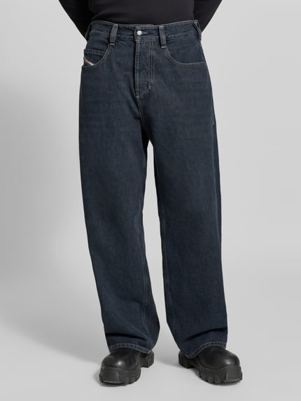 Männermodel trägt Relaxed Fit Jeans aus reiner Baumwolle von Diesel in dunklem Blau, 5-Pocket-Design, Label-Detail, Ganzkörperansicht von vorne.