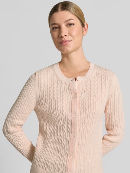 Frauenmodel trägt Regular Fit Strickjacke aus Baumwoll-Mix von Lacoste in zartem Rosa, feine Strickstruktur, Nahaufnahme Oberkörper, Damen Strickjacke von Lacoste.