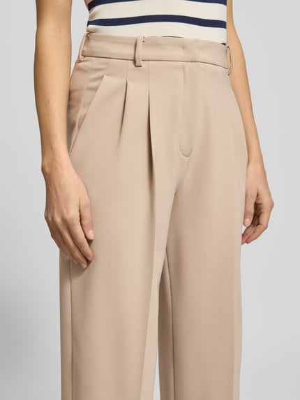 Kobiece modelka nosi spodnie materiałowe Wide Fit Stoffhose mit Gesäßtaschen Modell 'Emilie' von Cambio, kanty, zapinane na haftkę i zamek błyskawiczny, szerokość w rozmiarze 36: 39 cm, długość wewnętrzna nogawki w rozmiarze 36: 81 cm, z tyłu kieszenie, beżowy, gładka tekstura, zbliżenie na górną część spodni, detal