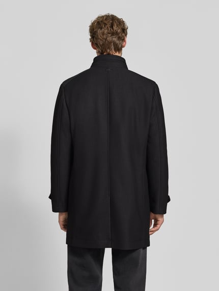 Männermodel trägt Kurzmantel mit Stehkragen und Ärmelriegeln von ROY ROBSON in Schwarz, Material-Mix, gerader Schnitt, Ganzkörperansicht Rückansicht.