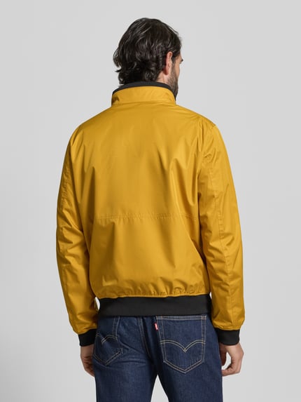 Männermodel trägt Regular Fit Jacke mit Stehkragen von MCNEAL, gelb, elastische Abschlüsse, Rückenlänge 64 cm, Ganzkörperansicht Rückansicht.