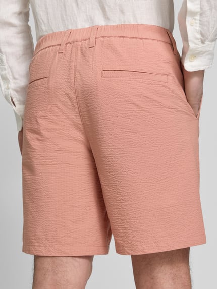 Männermodel trägt Regular Fit Bermudas aus Baumwoll-Mix Modell 'KARL' von SELECTED HOMME, Seersucker, hellrosa, Ganzkörperansicht Rückansicht