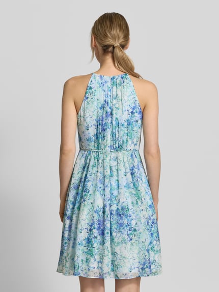 Vrouwenmodel draagt Minikleid in plooien-look met bloemen all-over print van Jake*s Cocktail, getailleerde pasvorm, ruglengte 87 cm, borstwijdte 35 cm, afneembare stoffen band, mouwloos design. Ganzkörperansicht Rückansicht.