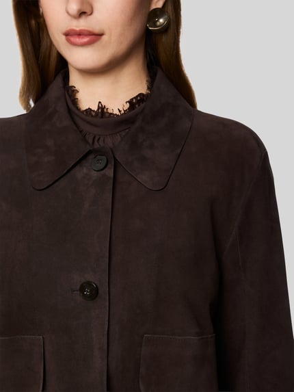 Frauenmodel trägt Regular Fit Lederjacke aus echtem Leder von Marc Cain in Dunkelbraun mit matter Textur, Nahaufnahme Oberkörper, Damen Leder- / Kunstlederjacke von Marc Cain.