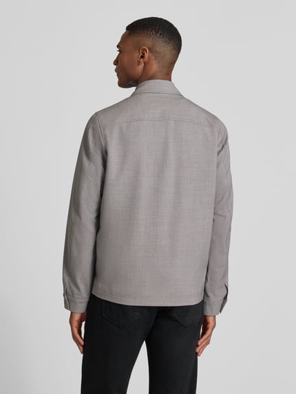 Männermodel trägt graue Regular Fit Jacke mit Viskose-Anteil Modell 'Jerson' von Drykorn, glatte Textur, Rückenansicht.