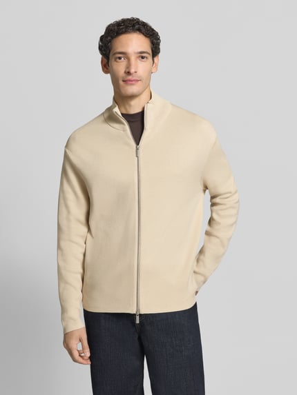 Männermodel trägt Strickjacke mit Zweiwege Reißverschluss von Selected Homme in Beige, Struktur, Stehkragen, Regular Fit, Ganzkörperansicht von vorne.