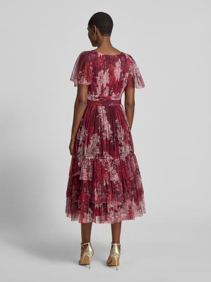 Frauenmodel trägt Cocktailkleid mit tiefem V-Ausschnitt von LACE & BEADS aus rotem Mesh, A-Linie, Stufen-Look, Taillenband, Ganzkörperansicht Rückansicht