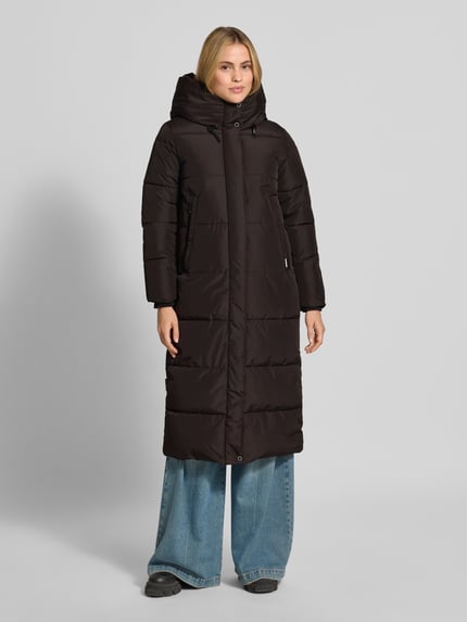 Frauenmodel trägt Regular Fit Mantel in Stepp-Optik Modell 'SOULANI' von khujo in Dunkelbraun, mit Kapuze und Stehkragen, Ganzkörperansicht von vorne.