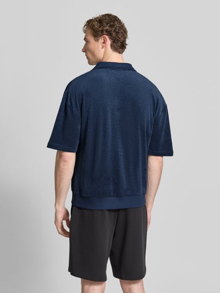 Męski model nosi Regular Fit Poloshirt aus Baumwoll-Mix Modell 'TERRANCE' von HUGO, efekt: jednolity kolor, krój relaxed fit, naszywka z logo, kołnierzyk polo, rękaw: krótki rękaw, wykończenie materiału: dzianina dresowa, mieszanka bawełny, Ganzkörperansicht Rückansicht.