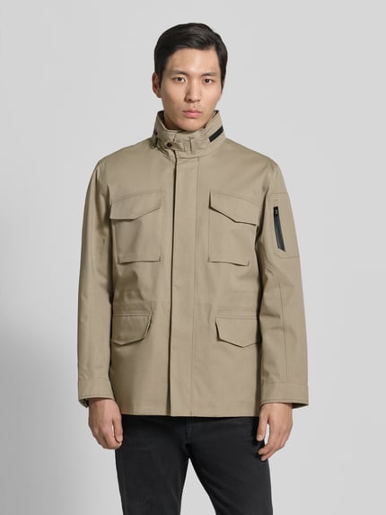 Männermodel trägt Jacke mit Stehkragen und Pattentaschen Modell 'DEFENDER' von G-LAB aus Baumwoll-Mix, Regular-Fit, Ganzkörperansicht von vorne.
