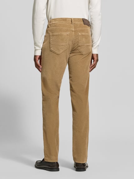 Männermodel trägt beige Straight Fit Cordhose aus Baumwoll-Mix Modell 'Mythos Flex Cord' von Brax, Herren Cordhose, Ganzkörperansicht Rückansicht.