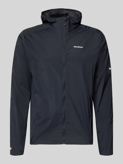 Produktfoto, Windbreaker mit Kapuze und Logo von Salomon, mieszanka materiałów z dodatkiem streczu, krój regular fit, logo, kaptur, zamek błyskawiczny, długość tyłu w rozmiarze M: 72 cm, szerokość ramion w rozmiarze M: 46 cm, szerokość klatki piersiowej w rozmiarze M: 56 cm, długość rękawów w rozmiarze M: 69 cm, kolor ciemny, gładka tekstura