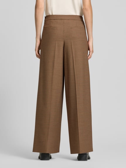 Frauenmodel trägt Relaxed Fit Stoffhose mit Schurwoll-Anteil Modell 'GHINEA' von Marella, braun kariert, Ganzkörperansicht Rückansicht. Elastischer Material-Mix mit Bundfalten sowie Eingriff- und Gesäßtaschen, neutrale Textur.