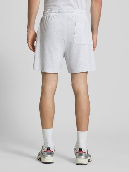 Männermodel trägt Regular Fit Poloshirt aus reiner Baumwolle von Tommy Jeans, Optik: Unifarben, Materialverarbeitung: Jersey, Ganzkörperansicht Rückansicht.
