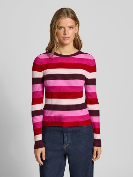 Frauenmodel trägt Regular Fit Pullover aus Viskose-Mix Modell 'IBI' von ONLY mit roten, pinken und weißen Streifen, Damen Pullover von ONLY, Ganzkörperansicht von vorne.