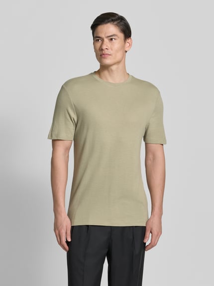 Męski model nosi Regular Fit T-Shirt aus Lyocell-Leinen-Mix Modell 'DULEROSTEE' od HUGO, jednolity, krój regular fit, krótki rękaw, okrągły dekolt, detal z logo, jasnobeżowy, gładka tekstura, widok całej sylwetki z przodu.
