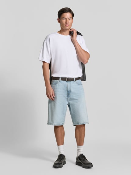 Männermodel trägt T-Shirt mit überschnittenen Schultern von Diesel in Weiß, lockere Passform, Rundhalsausschnitt, Baumwoll-Elasthan-Mix, Ganzkörperansicht von vorne.