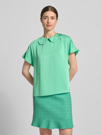 Frauenmodel trägt Blusenshirt aus Satin mit Umlegekragen von Marc Cain, Regular-Fit, grün, Knopfverschluss hinten, Ganzkörperansicht von vorne.