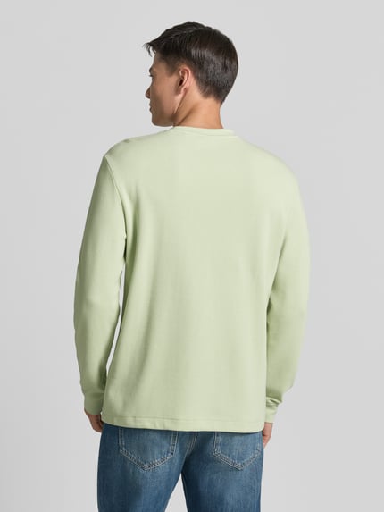 Männermodel trägt Regular Fit Langarmshirt aus Baumwoll-Mix Modell 'WE-TEMPEST' von BOSS Orange in Unifarben, Ganzkörperansicht Rückansicht.