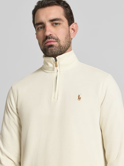 Męski model nosi Sweatshirt mit Stehkragen od Polo Ralph Lauren, kremowy kolor, bawełna, regular fit, zamek, widoczne logo, zbliżenie na górną część ciała