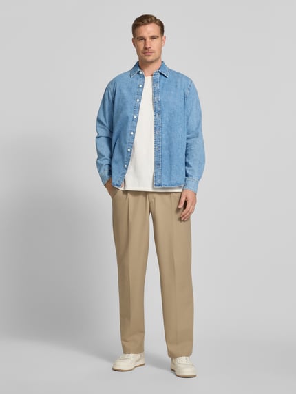 Männermodel trägt Regular Fit Jeanshemd mit Kentkragen von Gant aus Reine Baumwolle, blau, Knopfleiste, Langärmelig, Ganzkörperansicht von vorne.