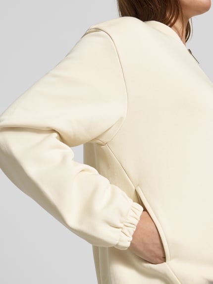 Vrouwenmodel draagt Boxy Fit Jacke aus Baumwoll-Mix van s.Oliver RED LABEL in effen kleur, lange mouw, steekzakken, elastische rompzoom, katoenmix. Detailopname van de zij.
